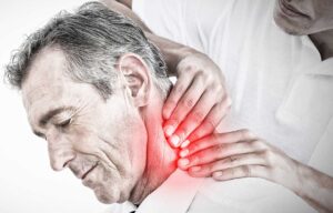 Person using a cold pack on the neck while seated at home after a car accident.